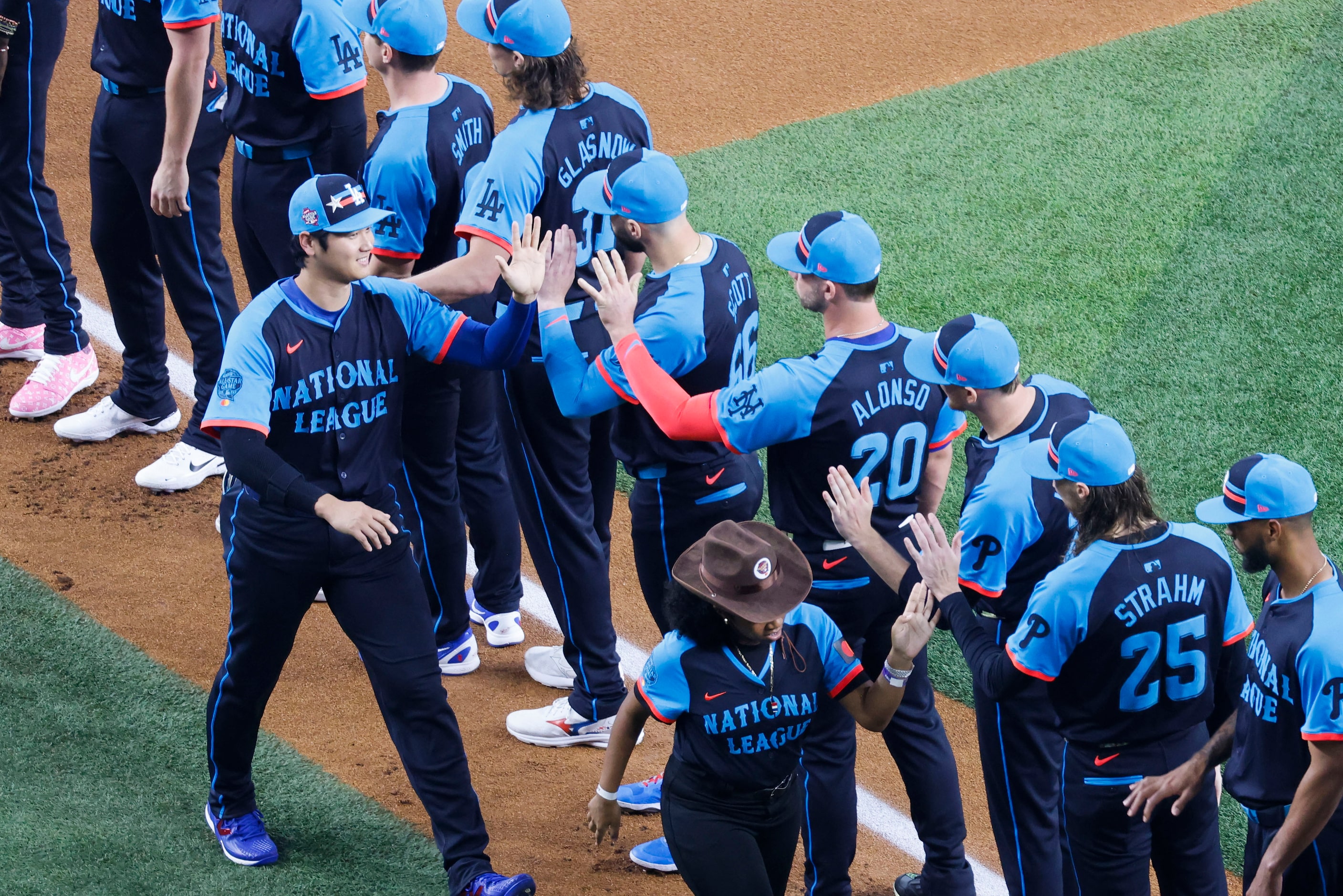 ational League's Shohei Ohtani, of the Los Angeles Dodgers high-fives his teammates upon...