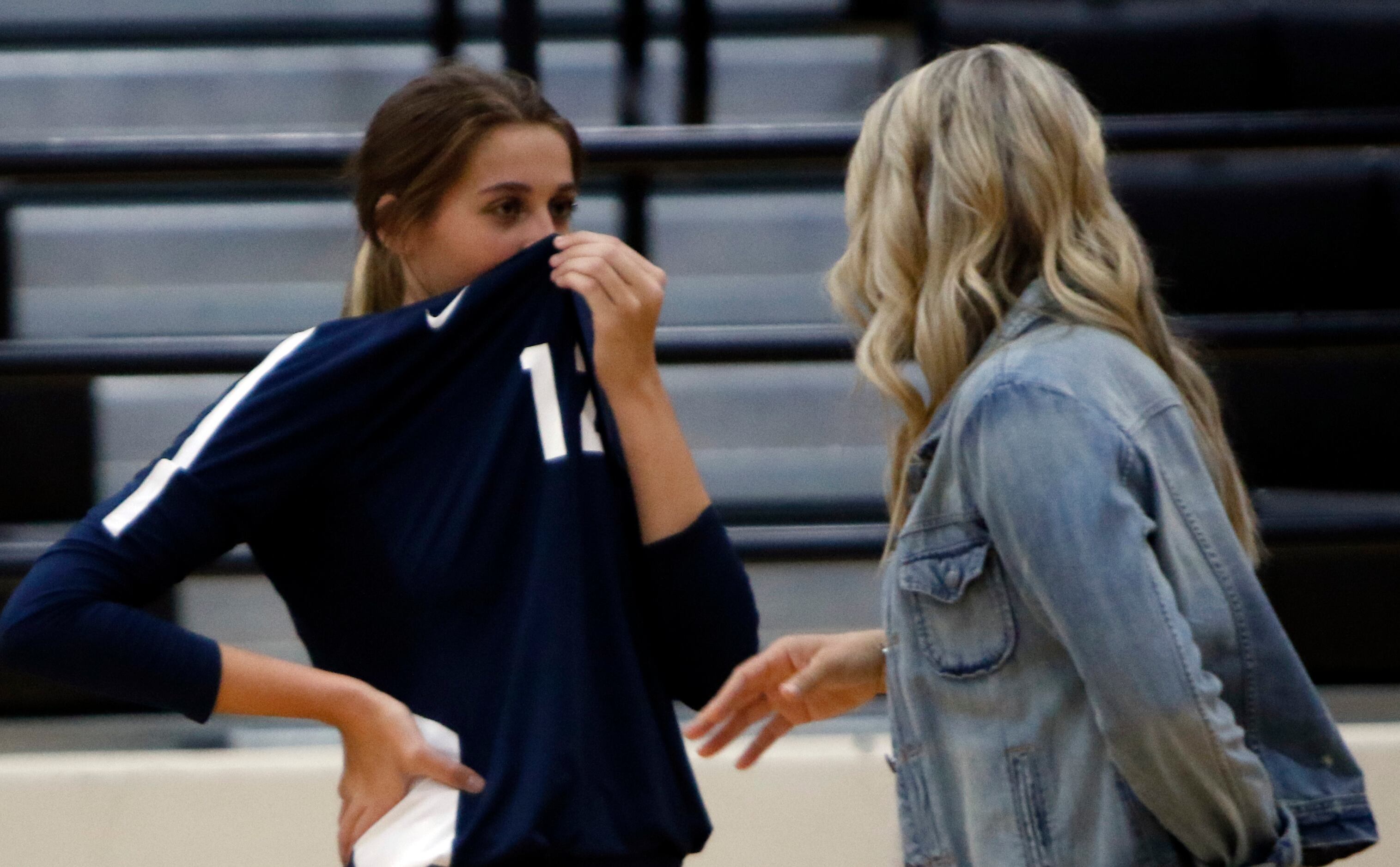Keller's Melanie McGann (12) uses her game jersey as a make-shift face covering while...