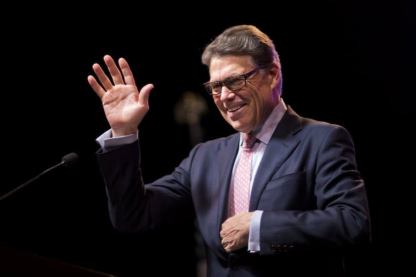 Former Texas Gov. Rick Perry waves to the crowd as he steps to the podium to speak at the...