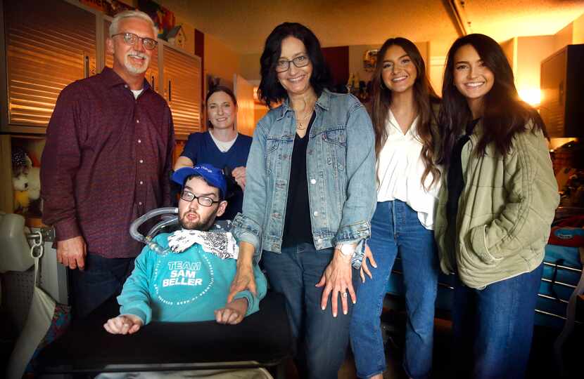 Sam Beller in his room at home with (from left) his father David, nurse Michelle Erving,...