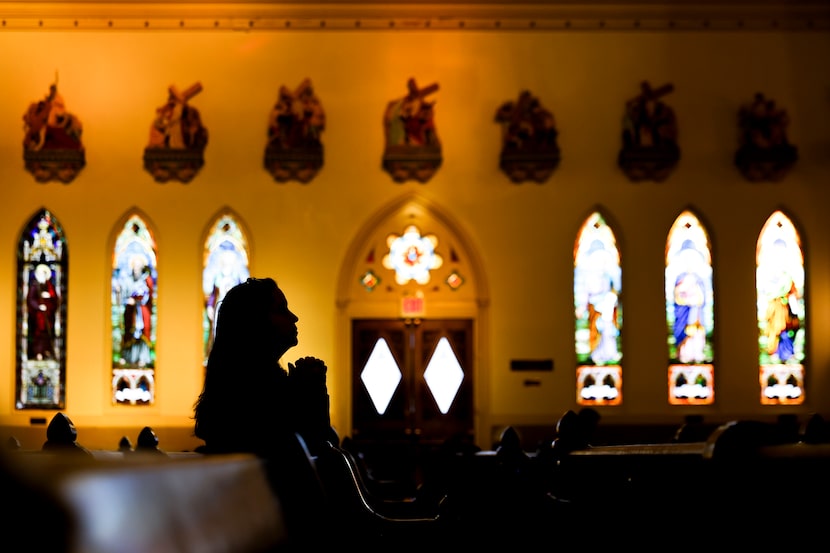 Monica Treviso of Carrollton stops by after work to pray ahead of a Mass on Friday, Dec. 8,...