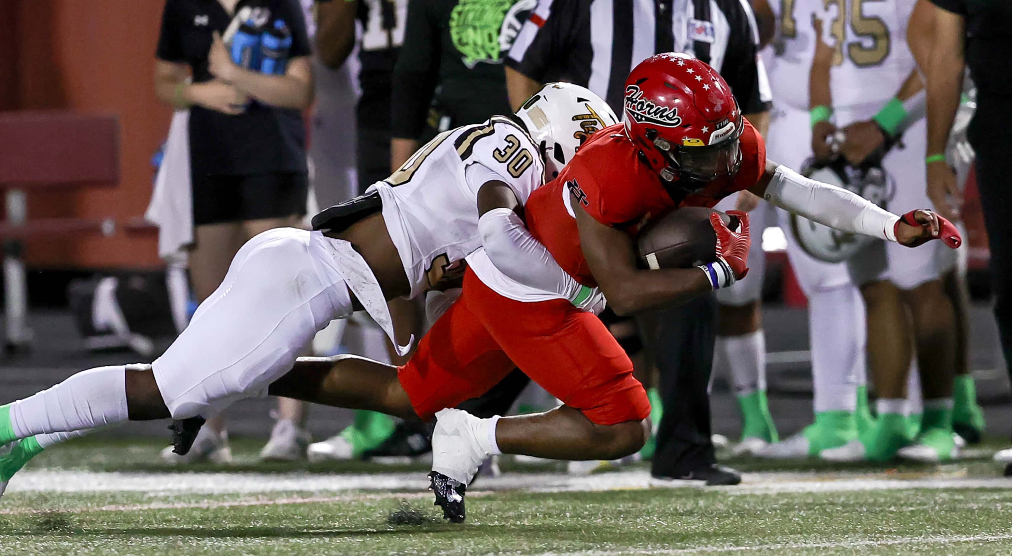 Cedar Hill running back Dayshun Reese-Williams (right) is stopped for big gain by Mansfield...
