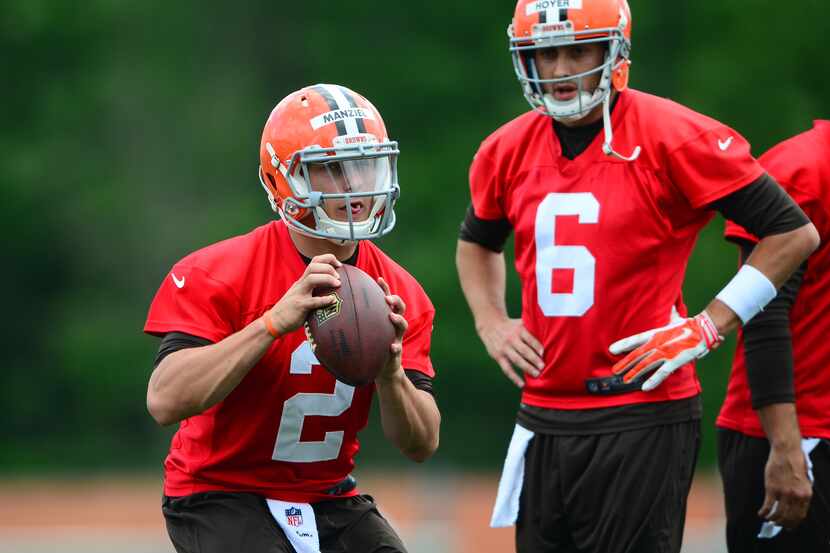 Cleveland Browns quarterback Johnny Manziel looks to pass as Brian Hoyer looks on during...