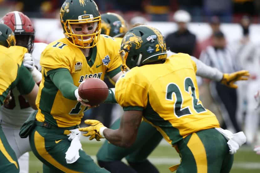 North Dakota State Bison quarterback Carson Wentz (11) hands the ball to running back King...