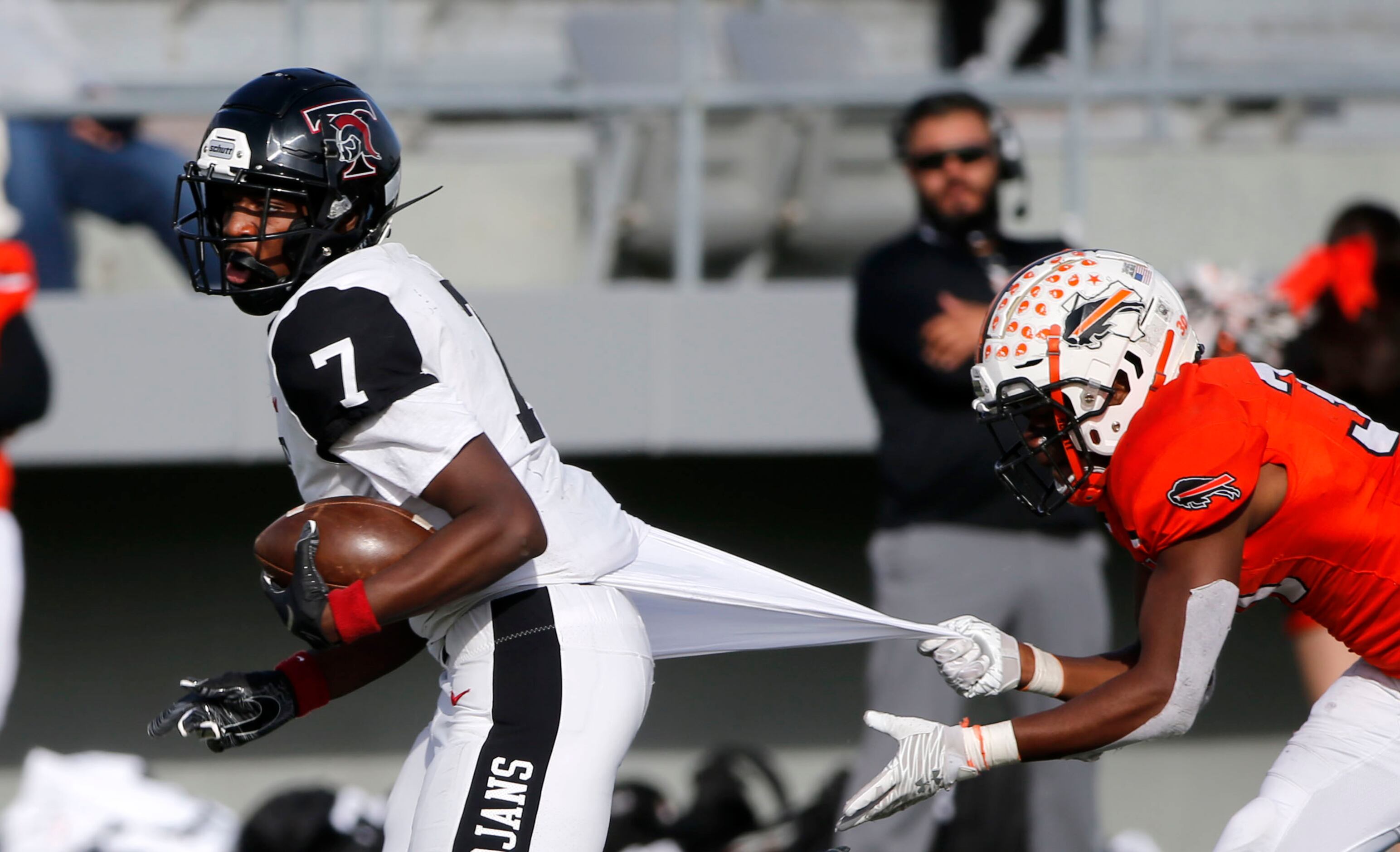 Euless Trinity wide receiver Jaquon Black (7) tries to get out of the grasp of Haltom...