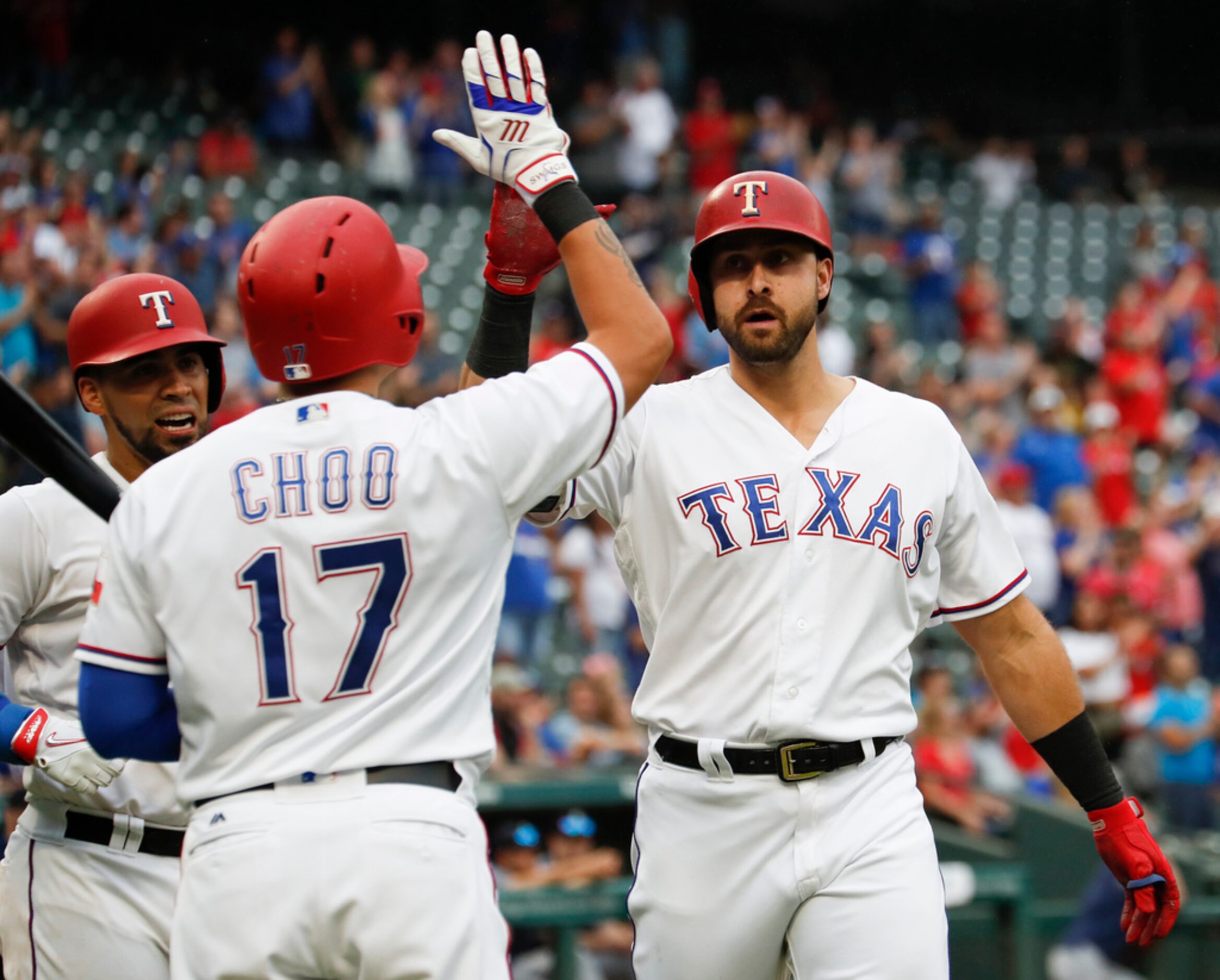 Texas Rangers' Joey Gallo, right, is congratulated by Shin-Soo Choo (17) and Robinson...