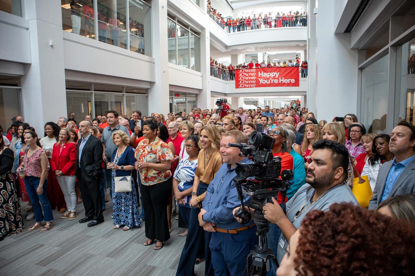 JCPenney employees and local Plano officials fill the three-level corridor of office space...