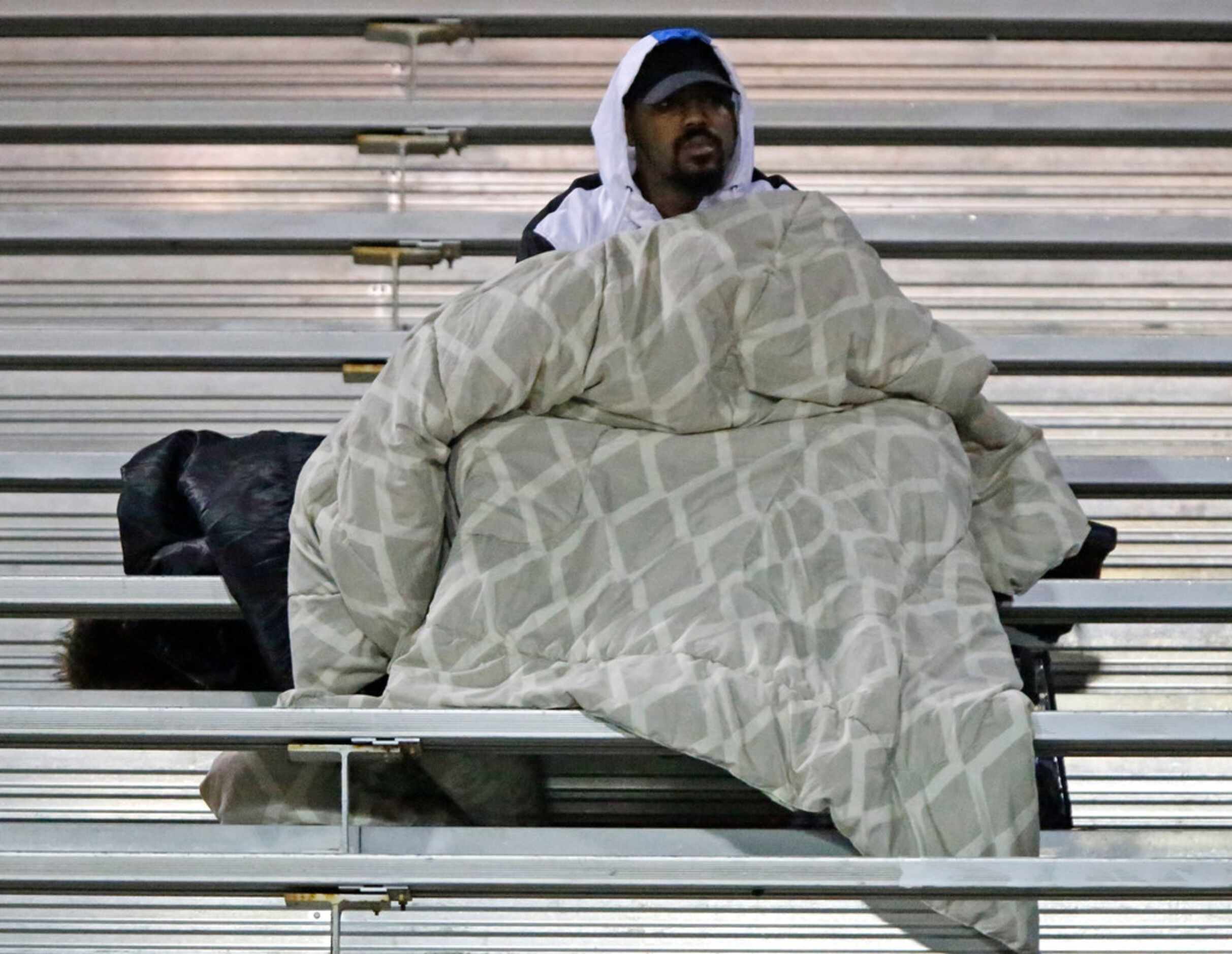 Darrius Richardson tries to keep warm in the stands while supporting his brother, Skyline...