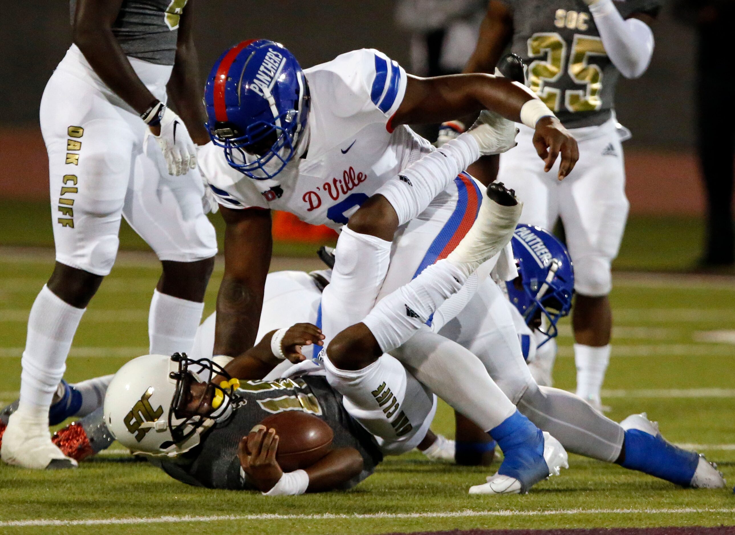 Duncanville’s Kendrick Blackshire (9) brings down South Oak Cliff QB Kevin Henry-Jennings...