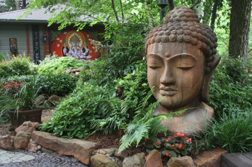 A large head of Buddha anchors the backyard garden of Brad Boling and Curtis Fesser. The...
