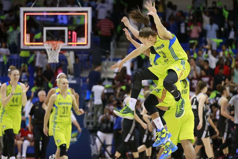 Dallas Wings forward Aerial Powers (23) and guard Odyssey Sims (0) celebrate their first win...