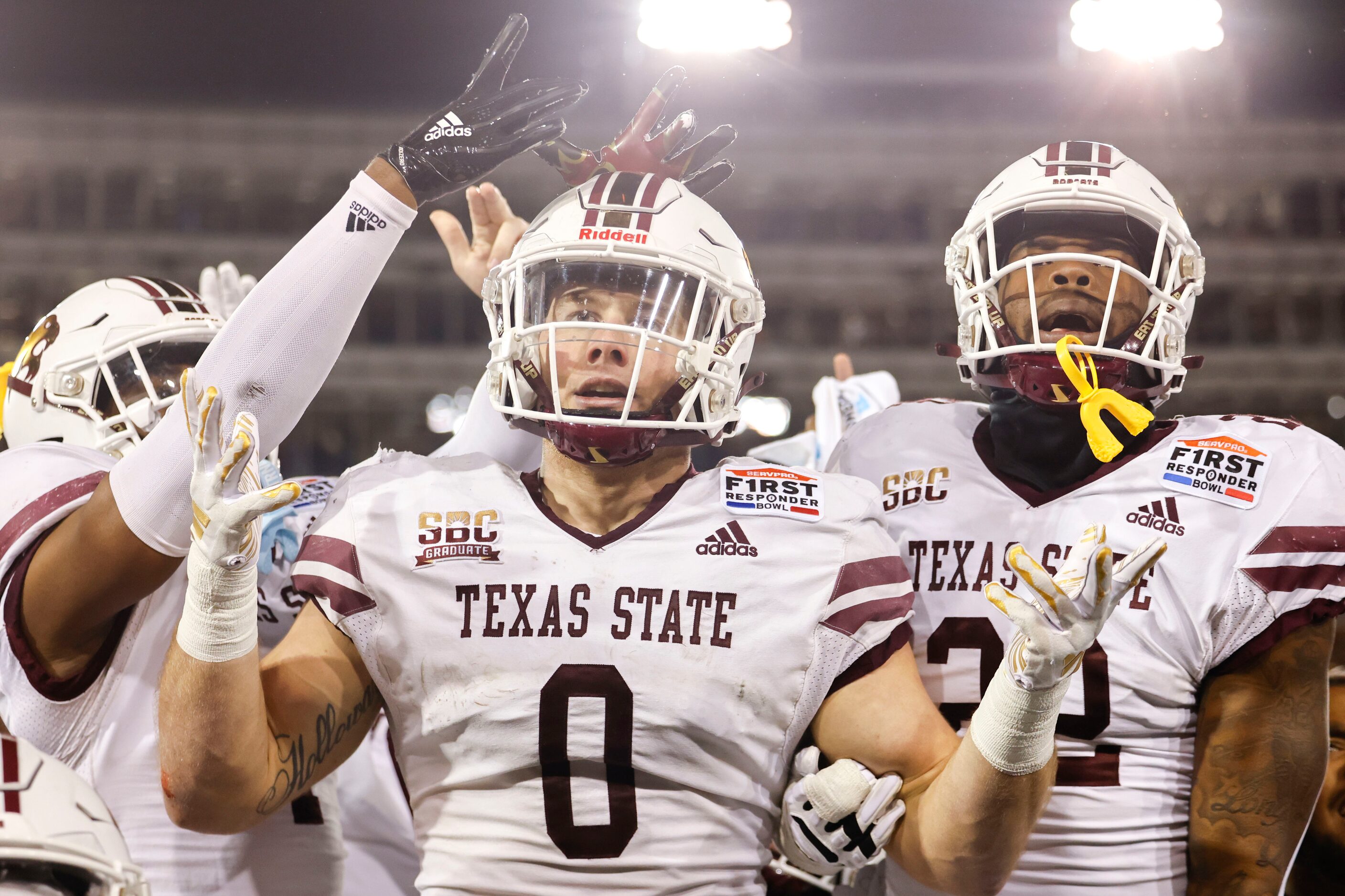 Texas State linebacker Brian Holloway (0) gets cheered by his teammates on the sideline...