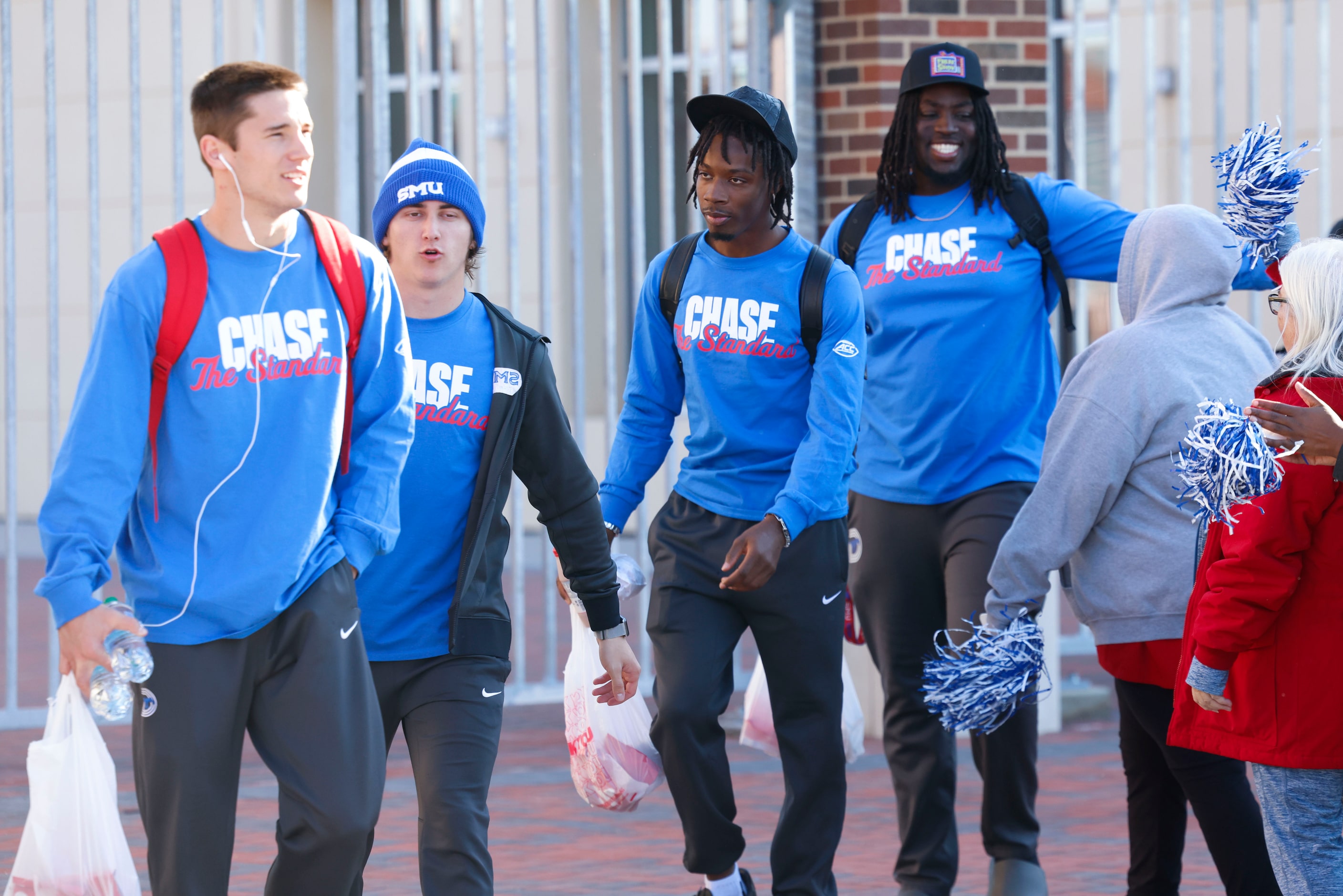 SMU QB Kevin Jennings (center) alongside his teammates make his way out during a send-off...