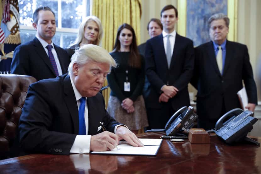 President Donald Trump signs one of five executive orders related to the oil pipeline...