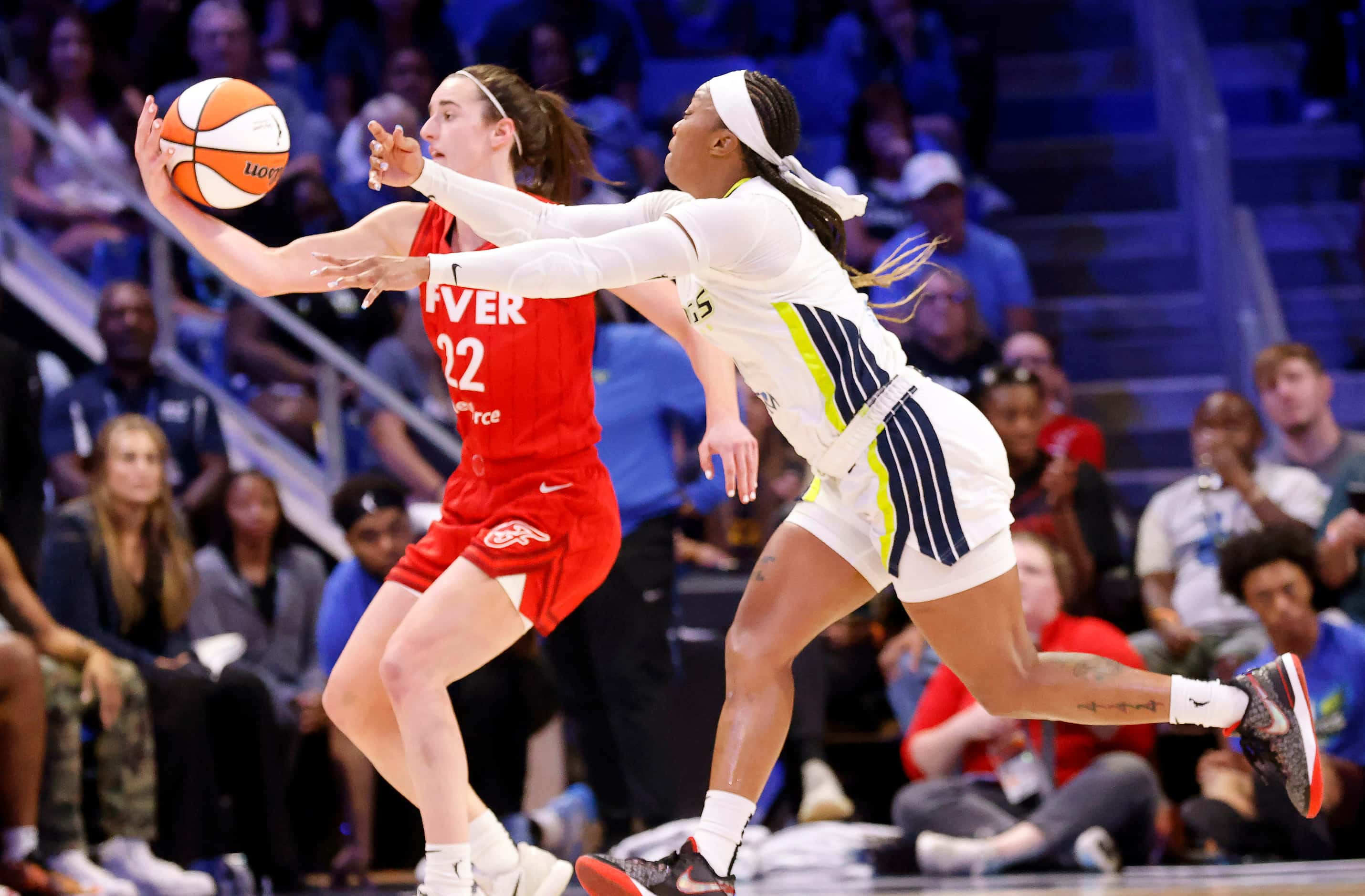 Dallas Wings guard Odyssey Sims (2) battles Indiana Fever guard Caitlin Clark (22) for the...