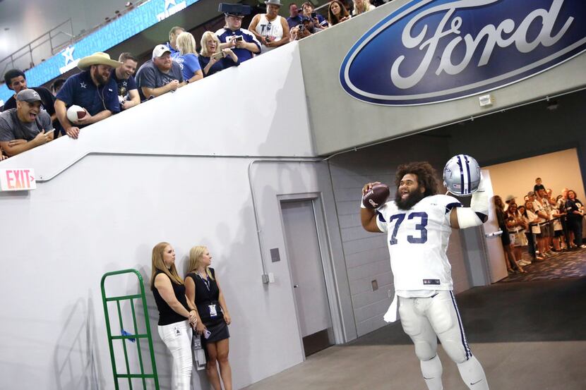 Dallas Cowboys center Joe Looney (73) cheers with fans during the Dallas Cowboys training...