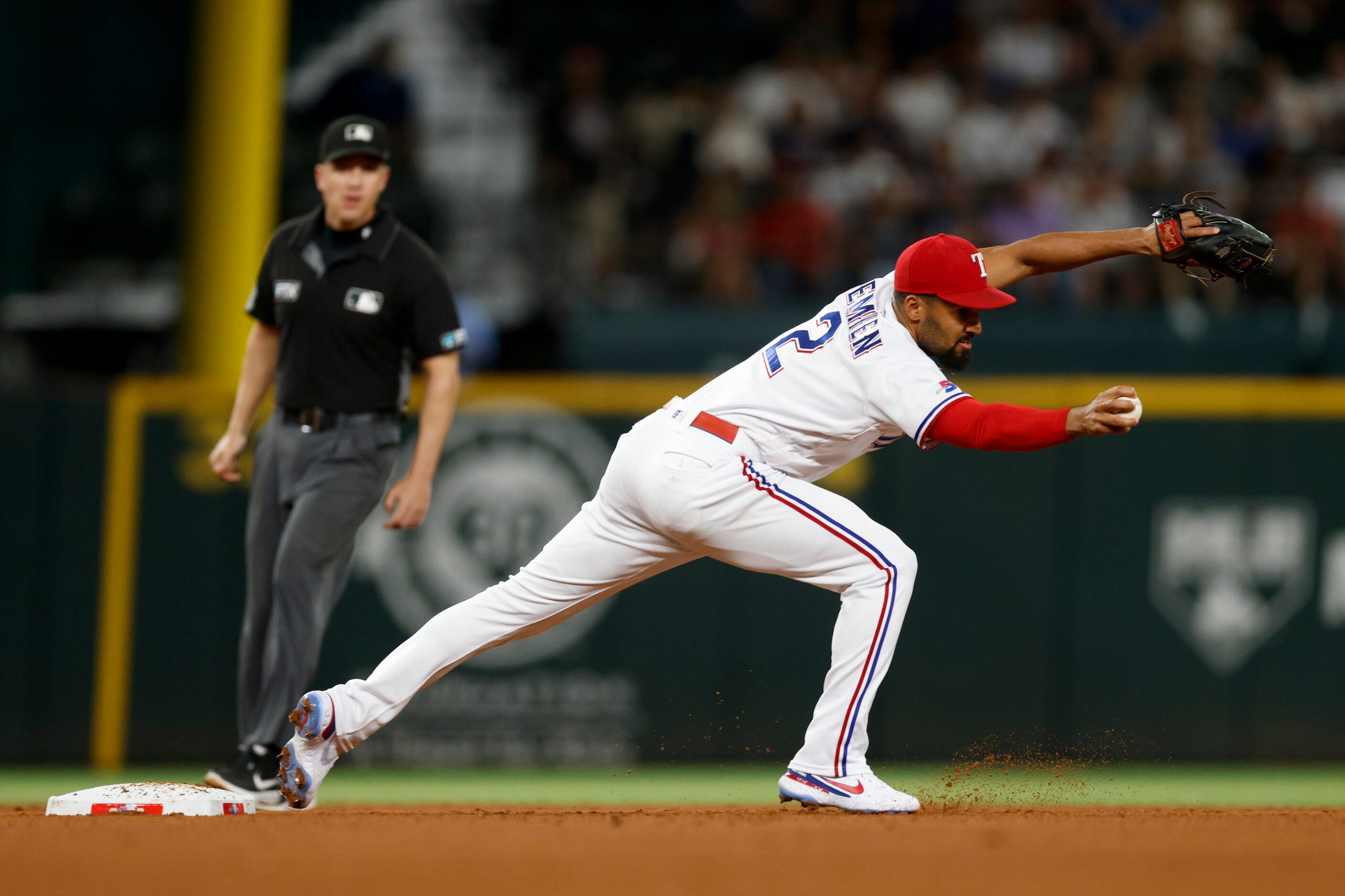 Texas Rangers second baseman Marcus Semien (2) stretches to field a toss from shortstop...