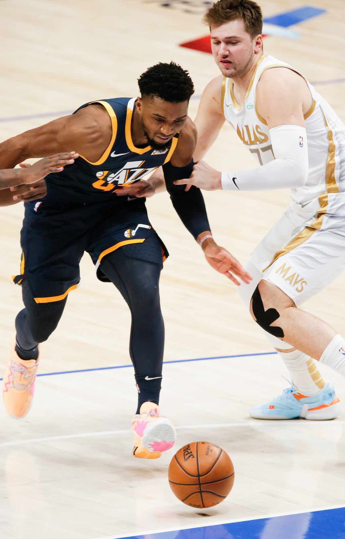 Utah Jazz guard Donovan Mitchell (45) battles past Dallas Mavericks guard Luka Doncic (77)...