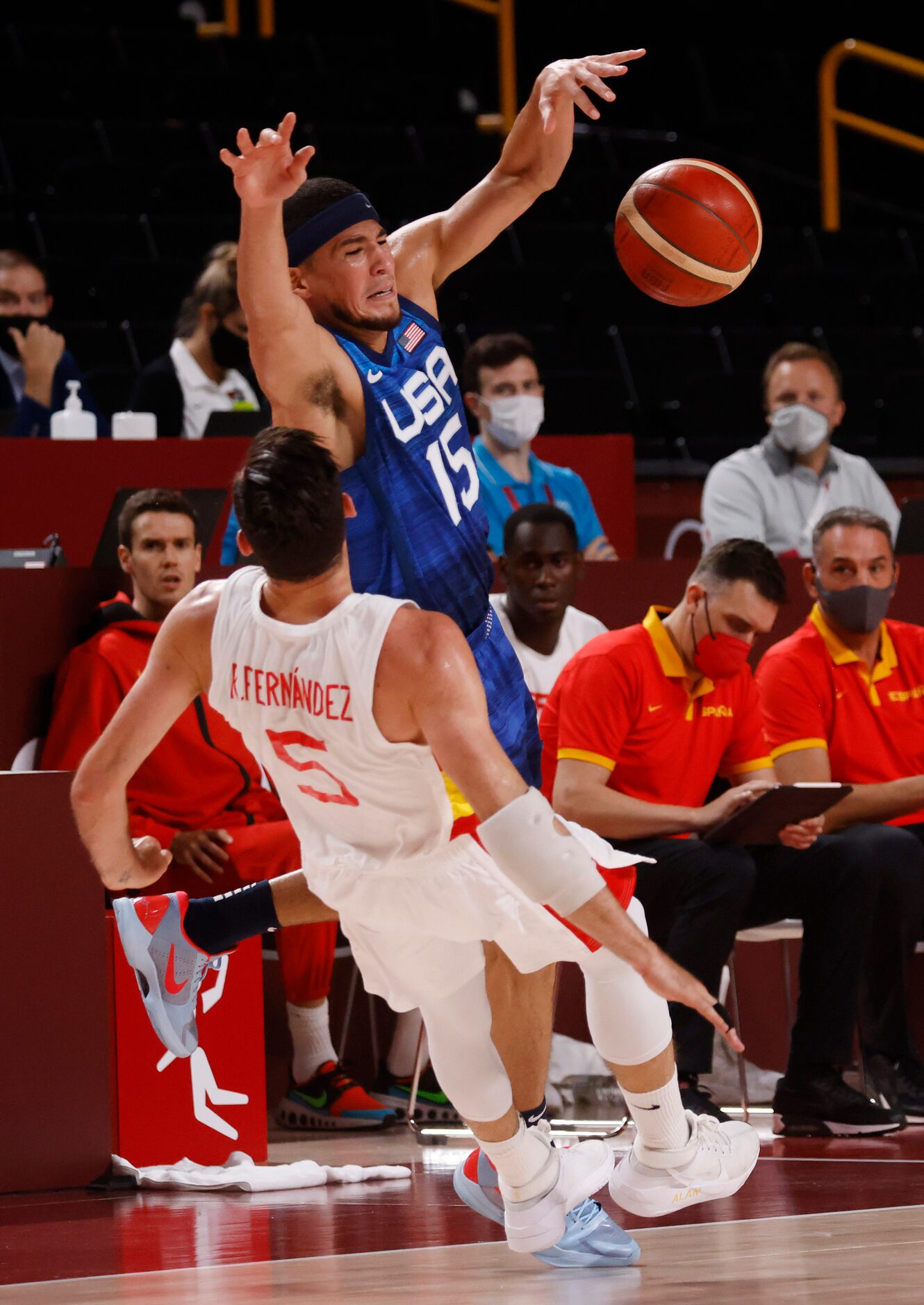 USA’s Devin Booker (15) is fouled by Spain’s Rudy Fernandez (5) during the first half of a...