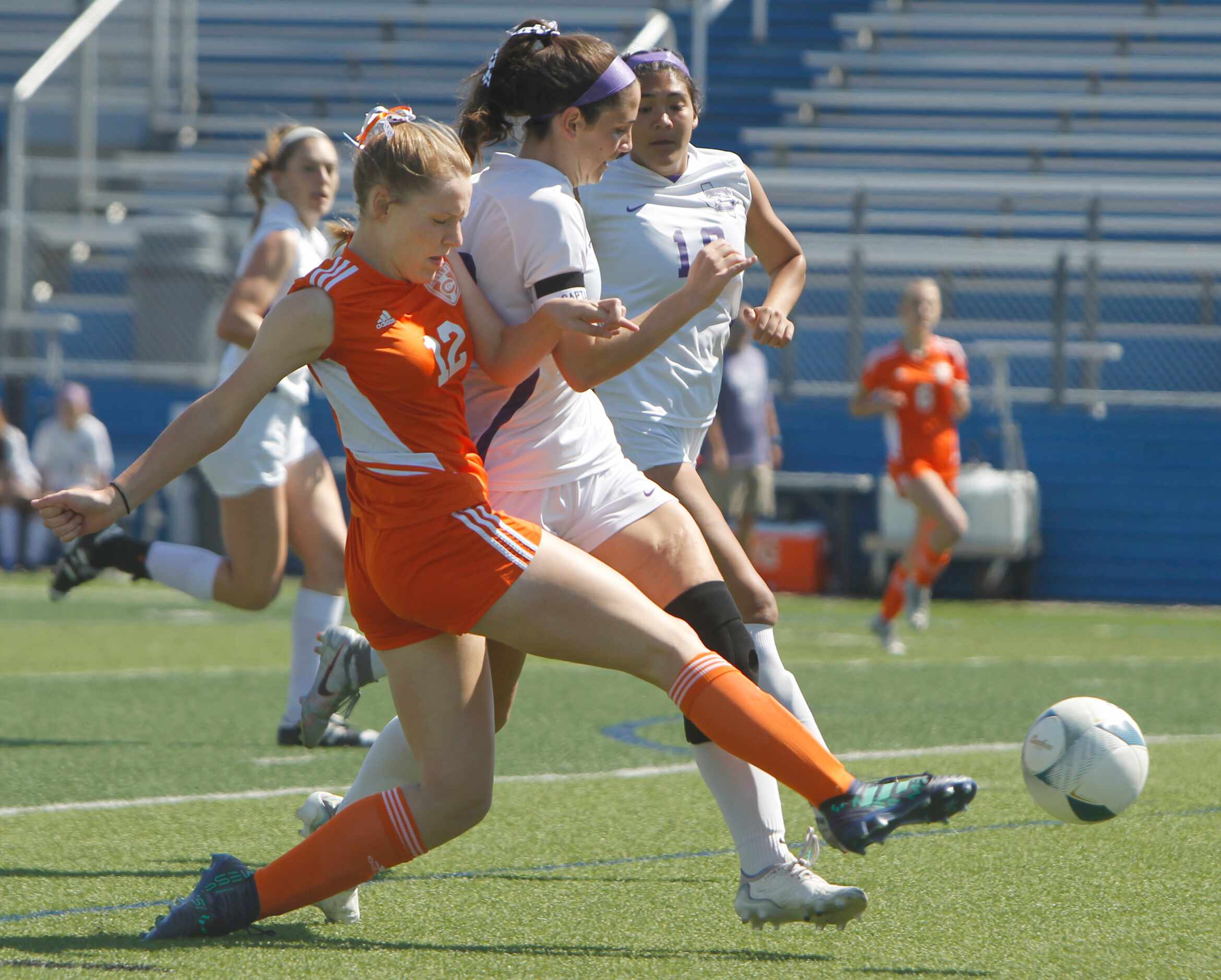 Celina's Grace Pritchard (12), left, lunges to clear the ball around the tight defense of...