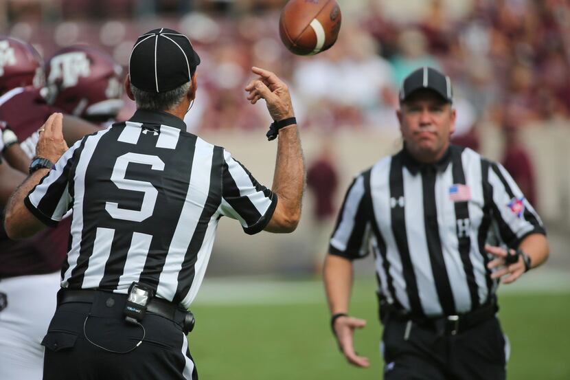 Side Judge Bobby Moreau tosses a game ball to Head Linesman Tim Sistrunk during the ...