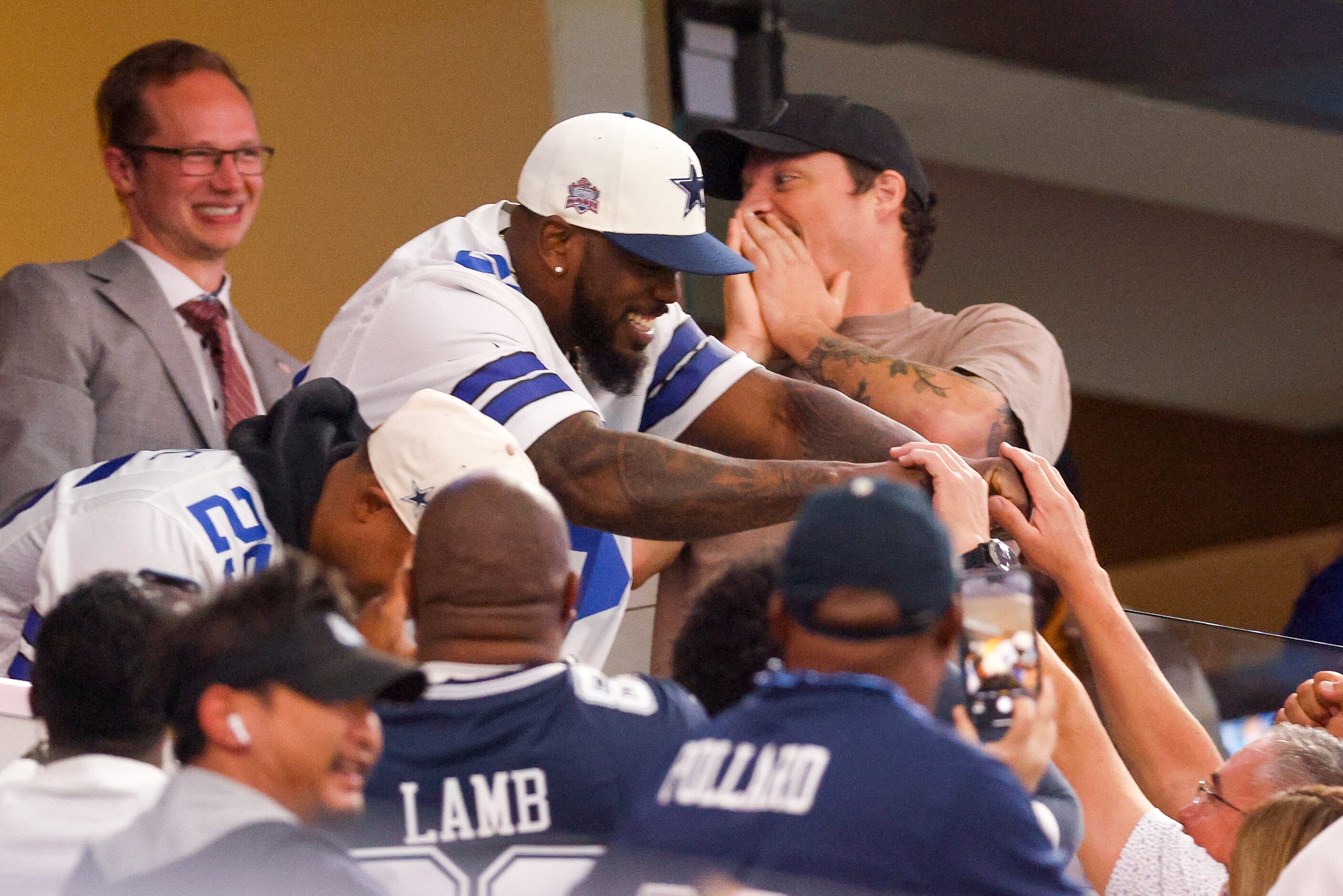 Texas Rangers outfielder Adolis Garcia fist bumps fans during the first half of an NFL game...