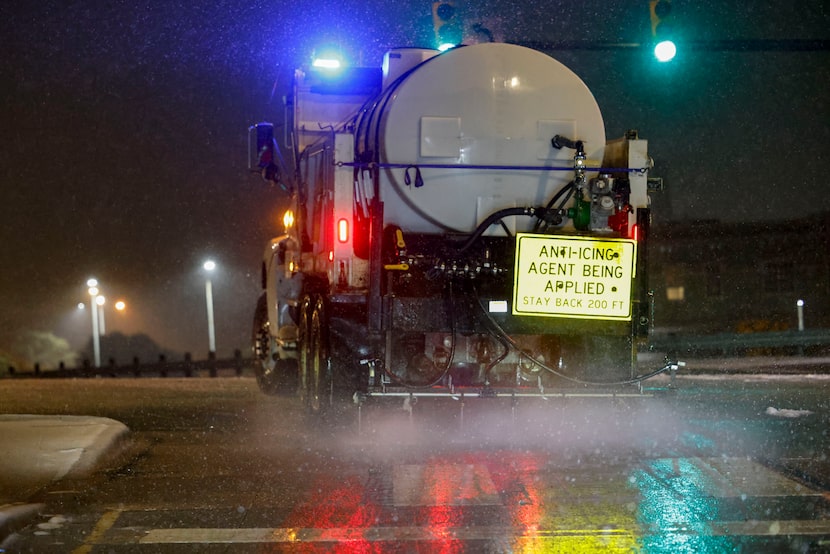 A TxDOT truck sprays an anti-icing agent along a frontage road near Interstate 30 and beach...