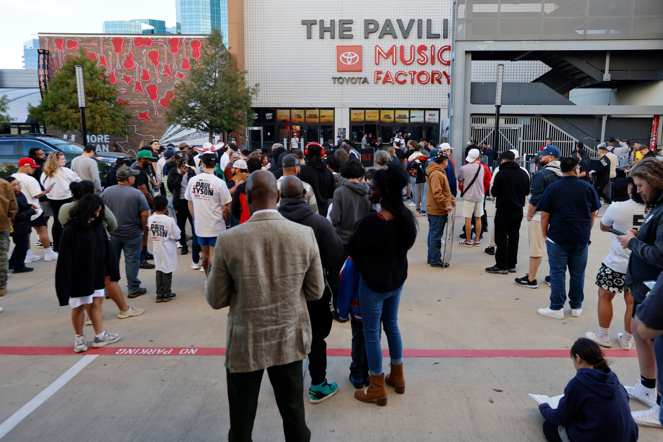 Fans wait outside before an open workout ahead of the Mike Tyson-Jake Paul boxing match at...