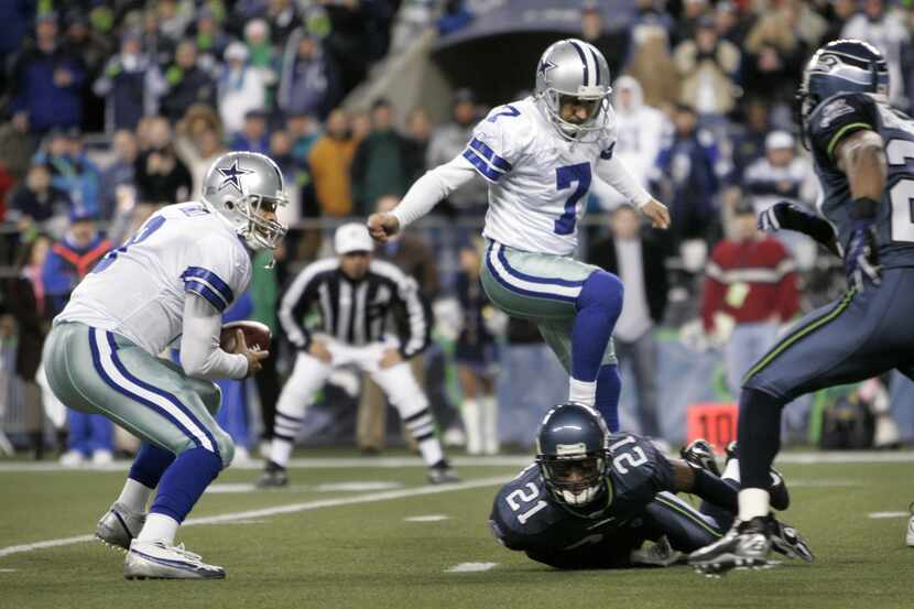 Tony Romo (left) looks for running room after fumbling the snap on a field goal try late in...