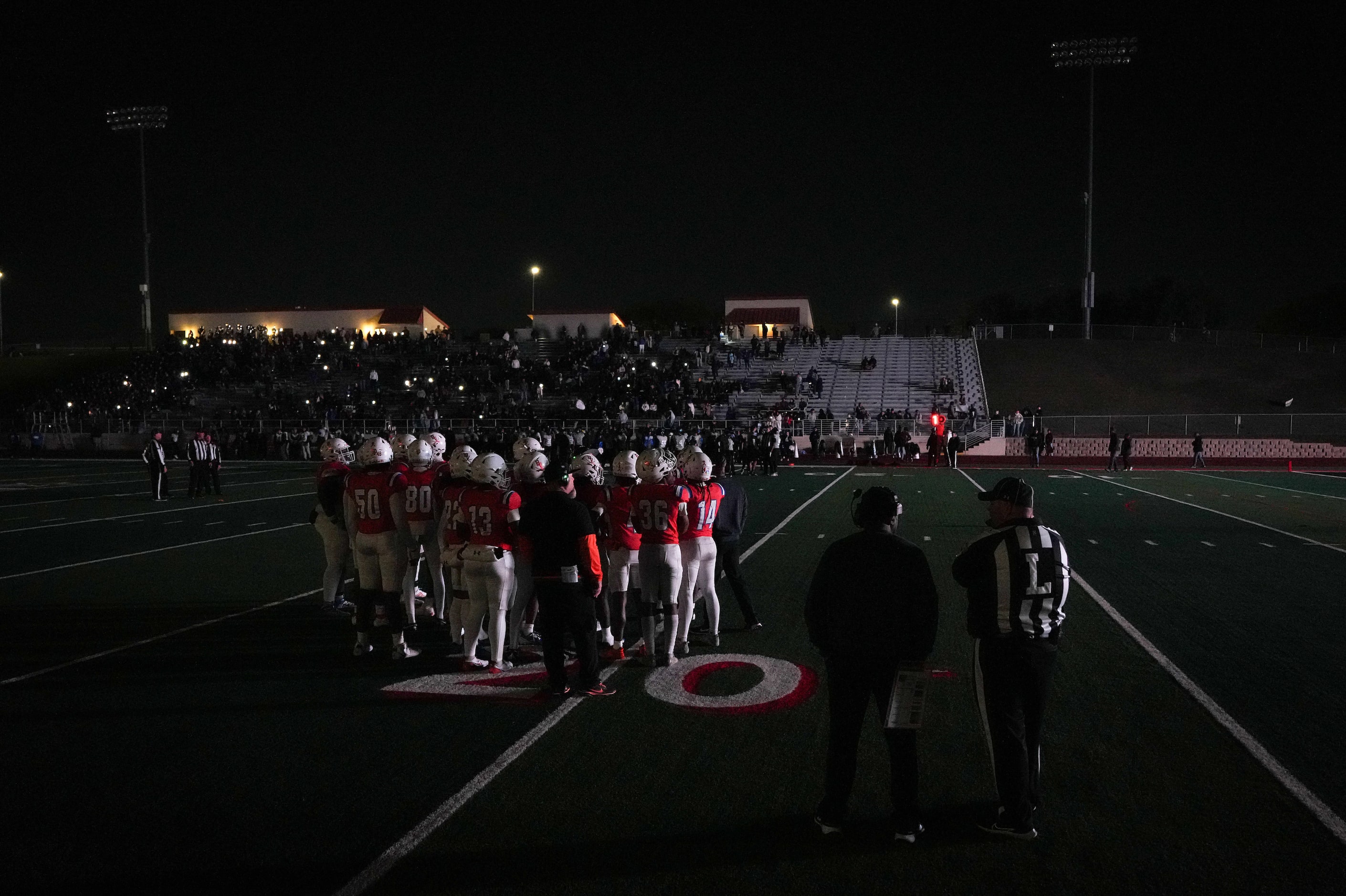 Arlington Bowie head coach Joseph Sam talks with officials on a darkened field during a...