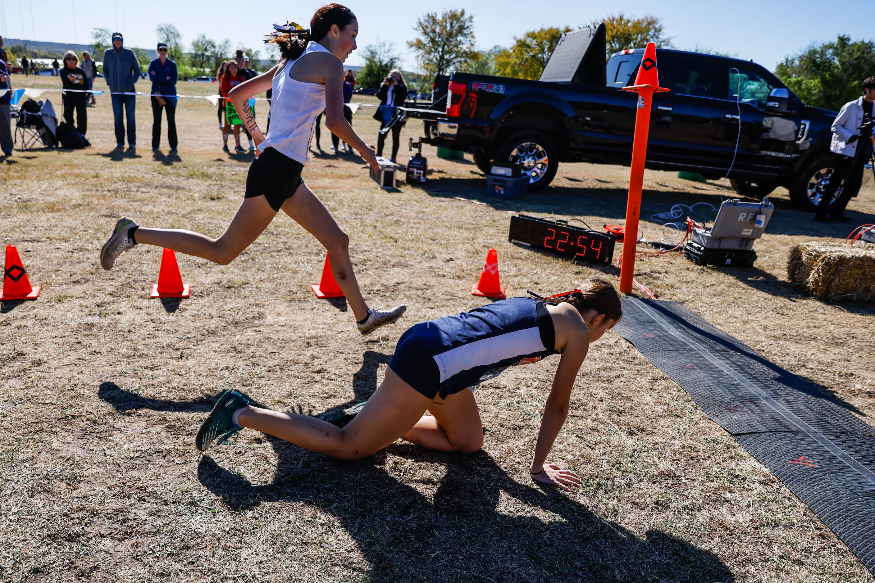 Emma Thomas (1538) from Frisco Wakeland team collapses before reaching the finish line as...