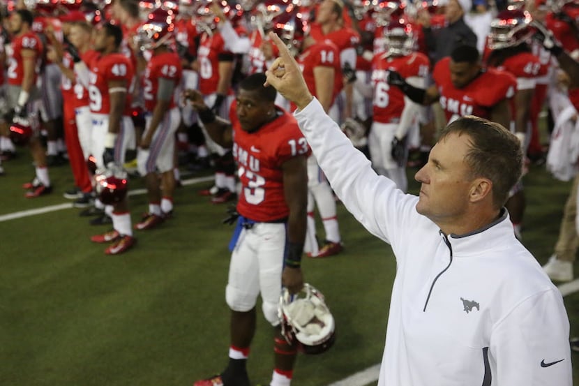 Chad Morris joins his players for the school song following an NCAA football game between...