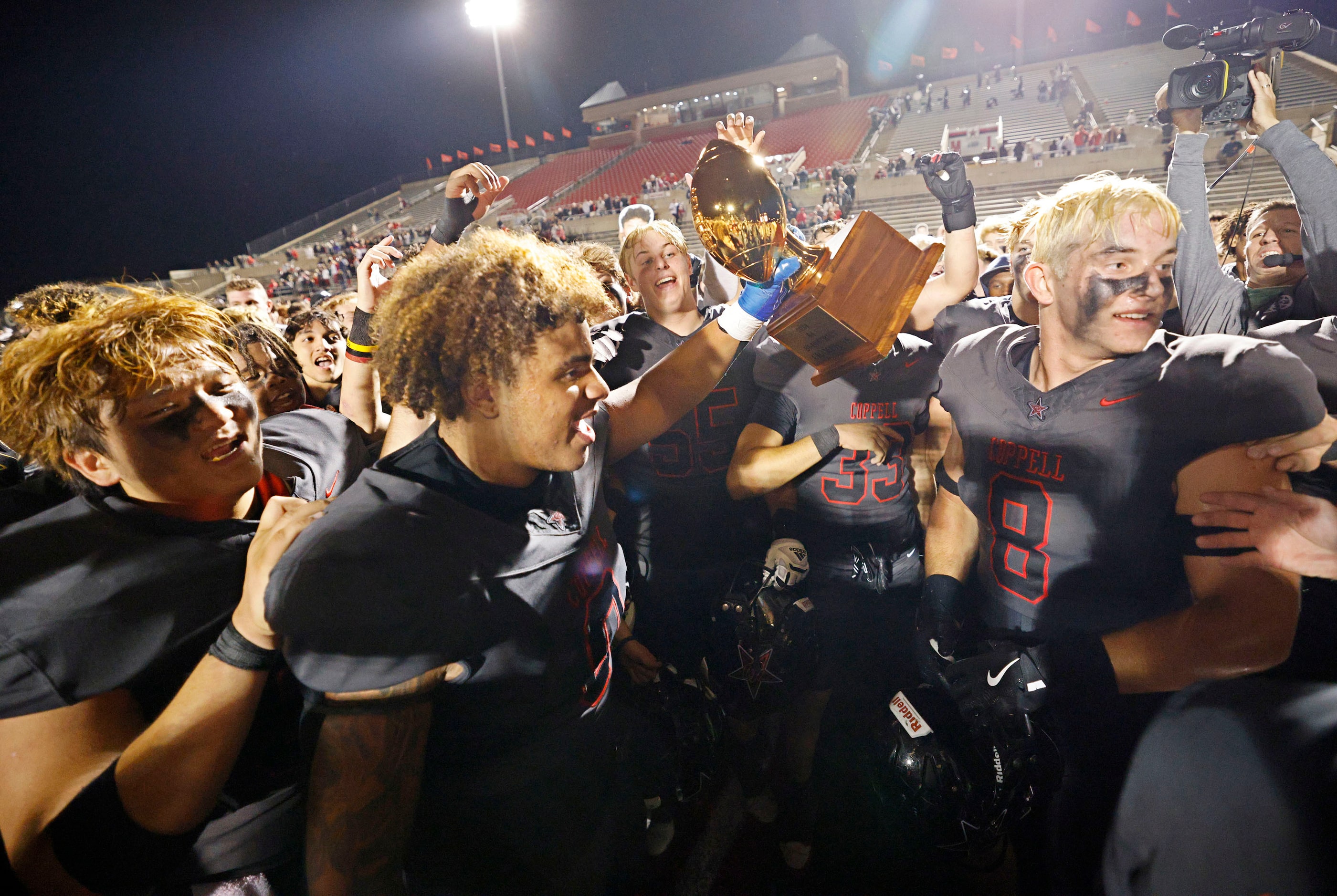 Coppell players celebrate their 35-27 victory against Prosper after a high school football...