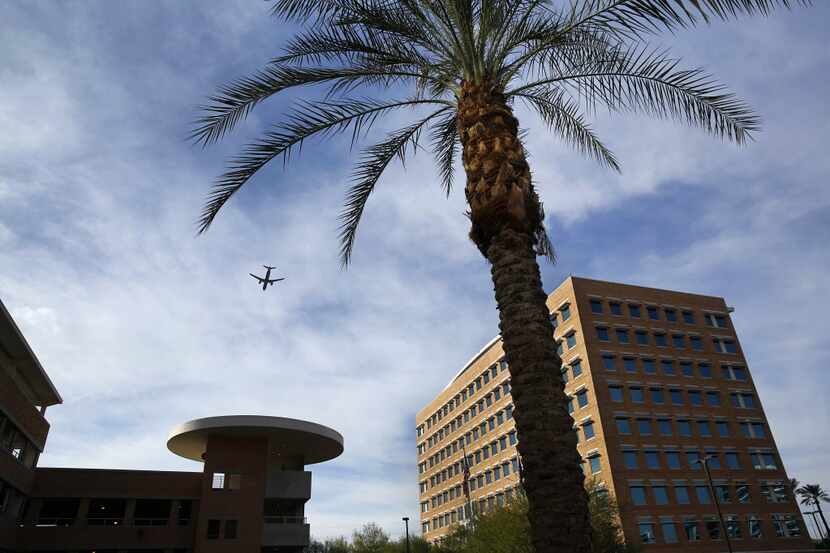 A passenger jet makes an approach to Sky Harbor International Airport over the US Airways...