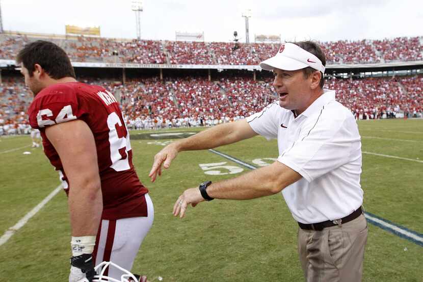 Oklahoma Sooners head coach Bob Stoops is all smiles as he congratulates offensive linesman...