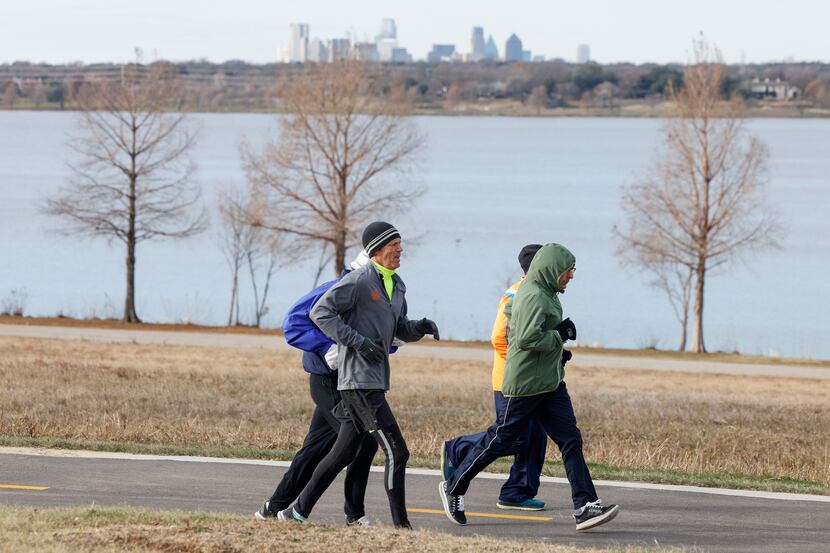 A group of people jog along White Rock Lake Trial at White Rock Lake in Dallas, Saturday,...