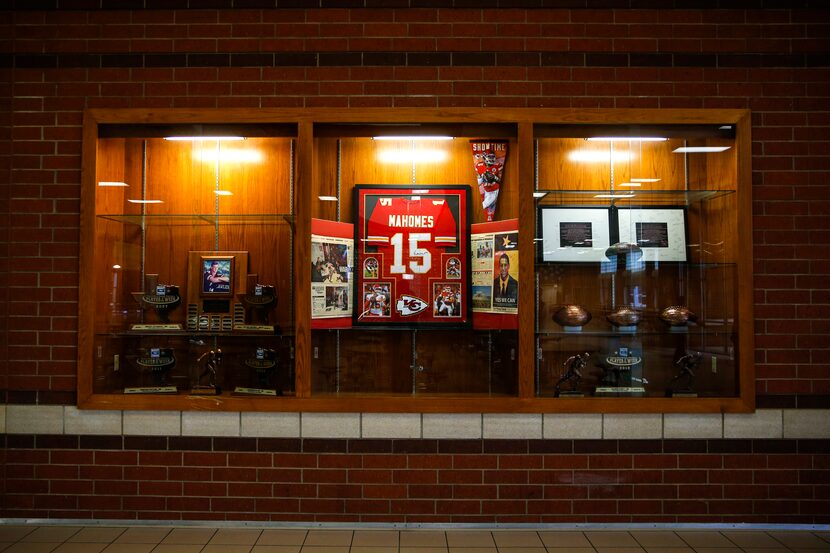 A Kansas City Chiefs jersey signed by quarterback Patrick Mahomes centerpieces the trophy...