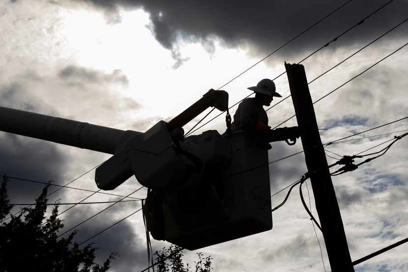 An Oncor crew member works to restore power on Junius Street after flooding, Aug. 23, 2022,...