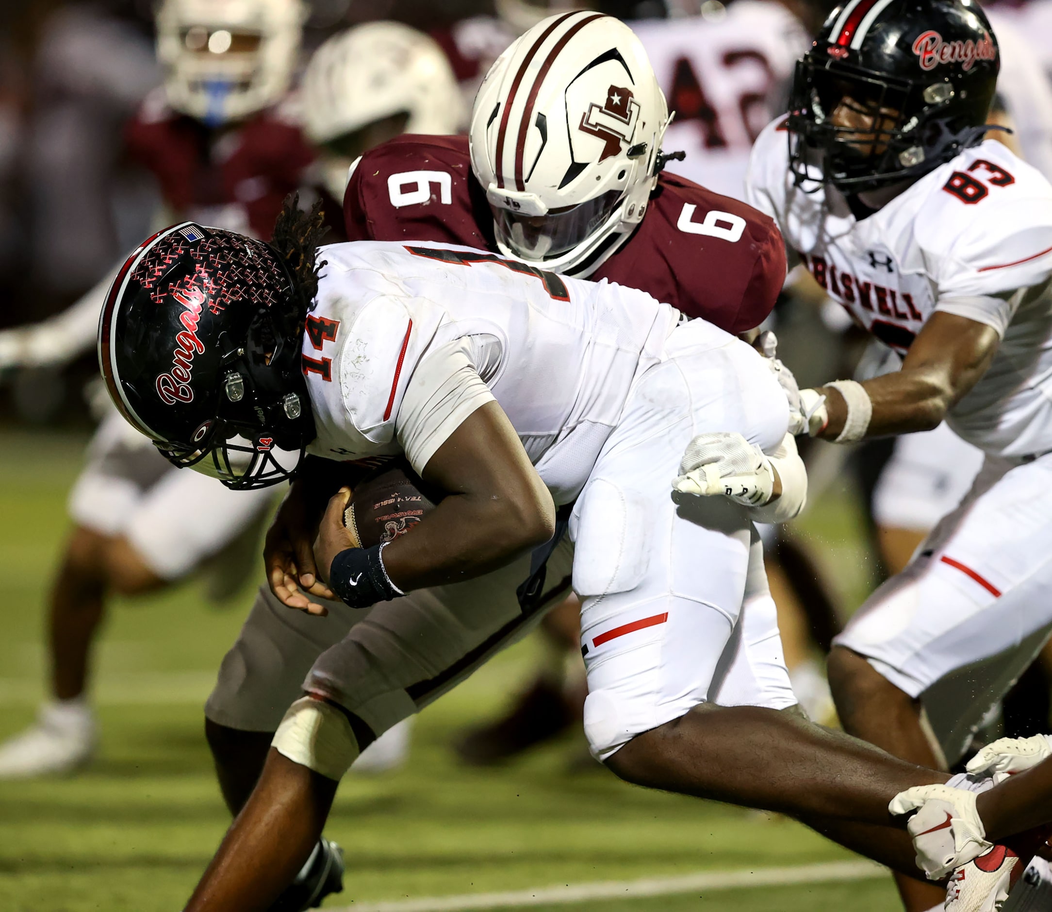 Denton Braswell quarterback Jeremiah Shipp (14) is stopped for a short gain by Lewisville...