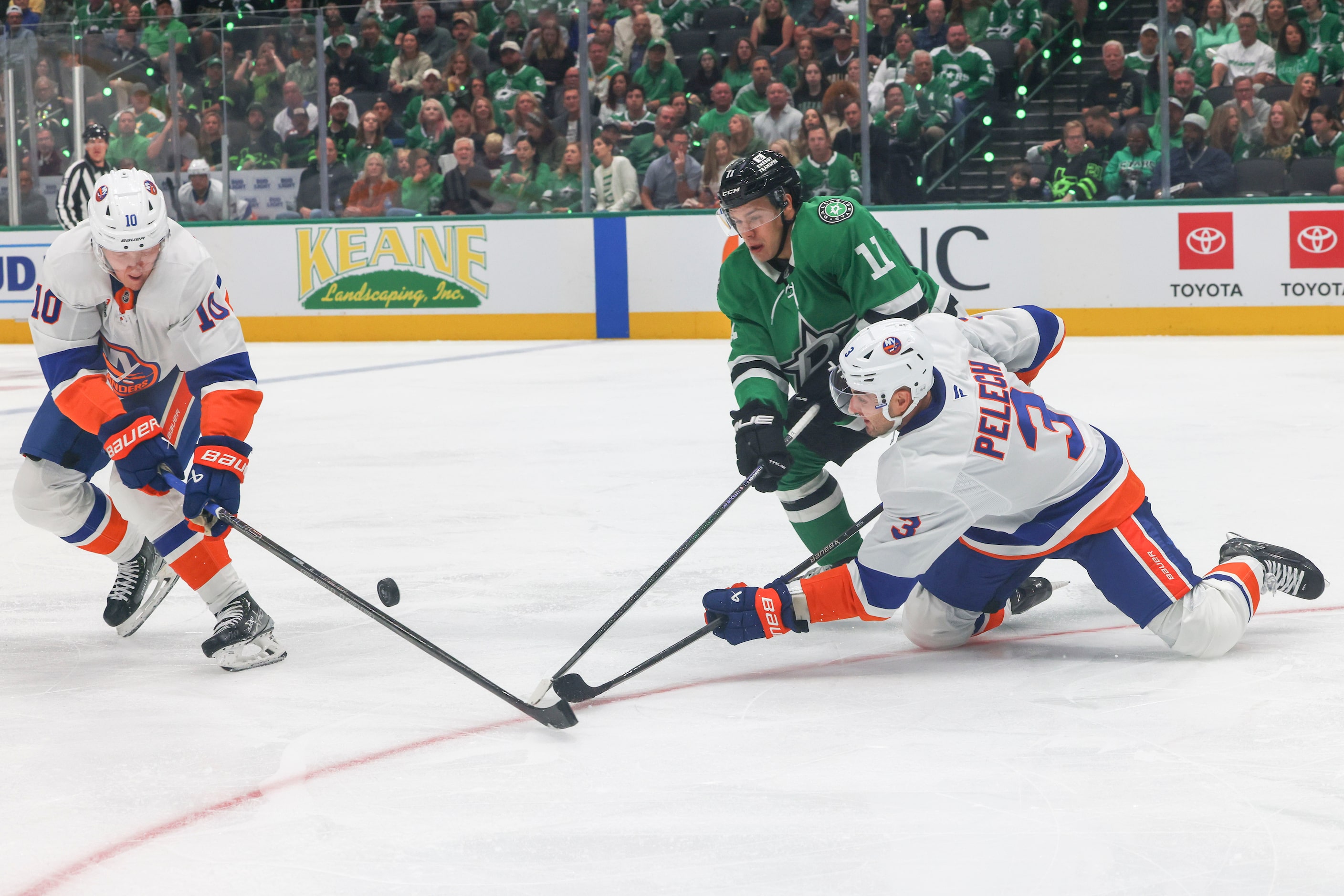 Dallas Stars center Logan Stankoven (11) fights for the puck against New York Islanders...