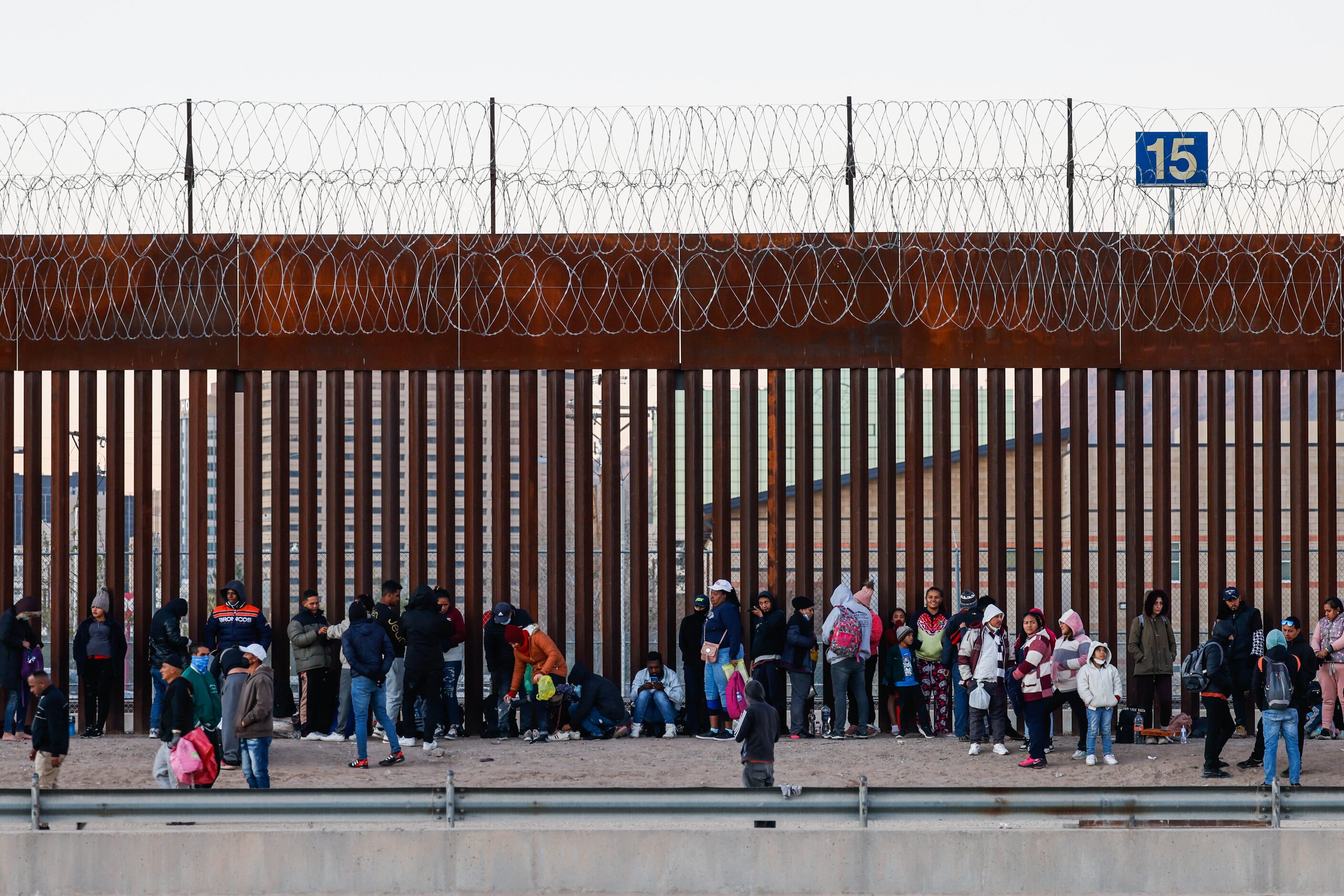 Migrants stand in line at a US-Mexico border gate from the banks of the Rio Grande River in...