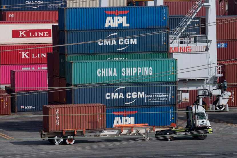 A truck passed by shipping containers at the Port of Los Angeles on Sept. 1, after new...