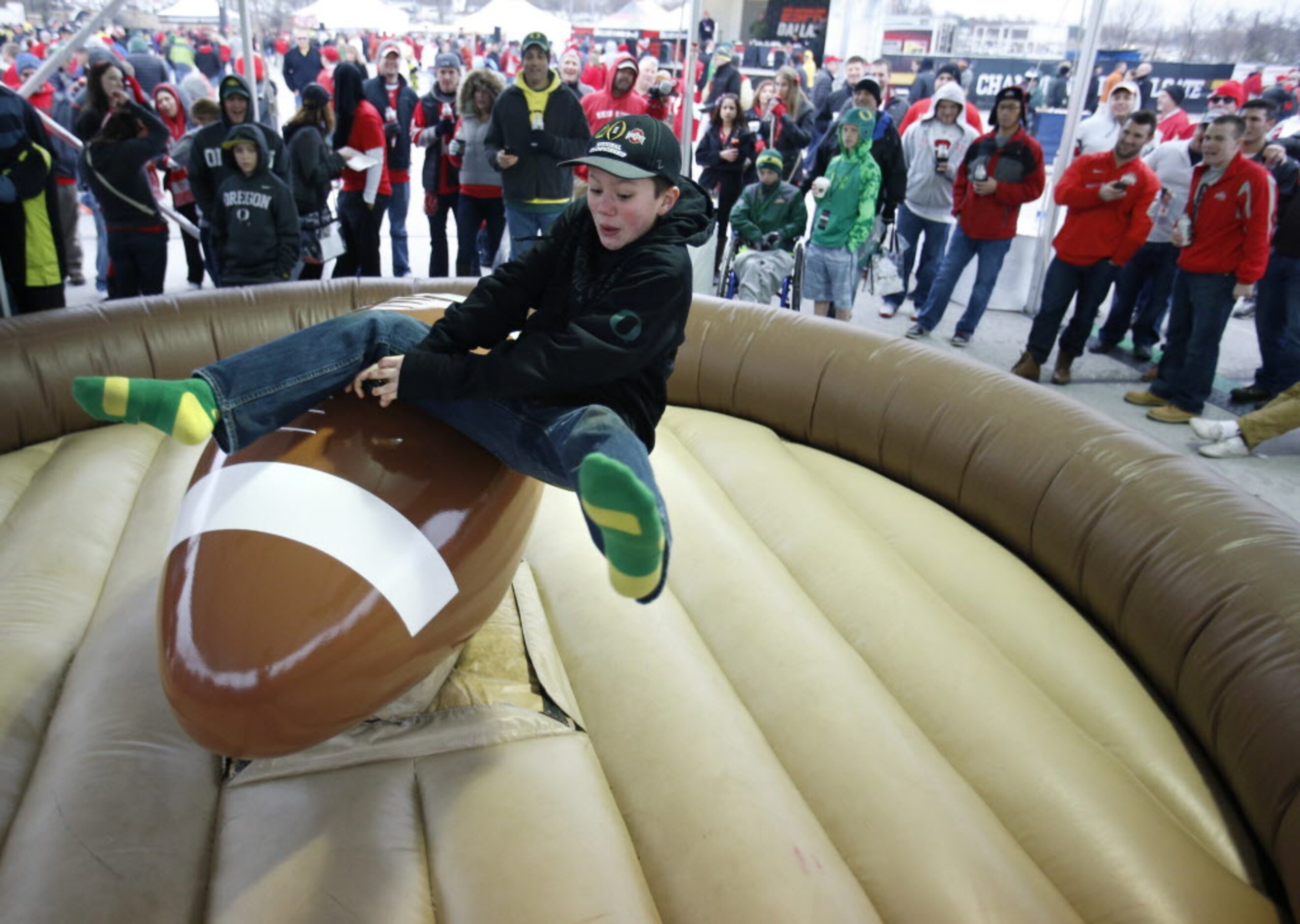 Joe Cross, 12 of Bend, Oregon falls off as he rides the "footbull" before a game between...