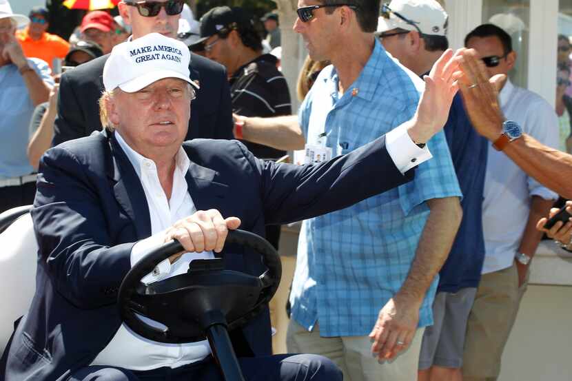 Donald Trump maneja un carro de golf en su campo de golf Mar-a-Lago en Doral, Florida.