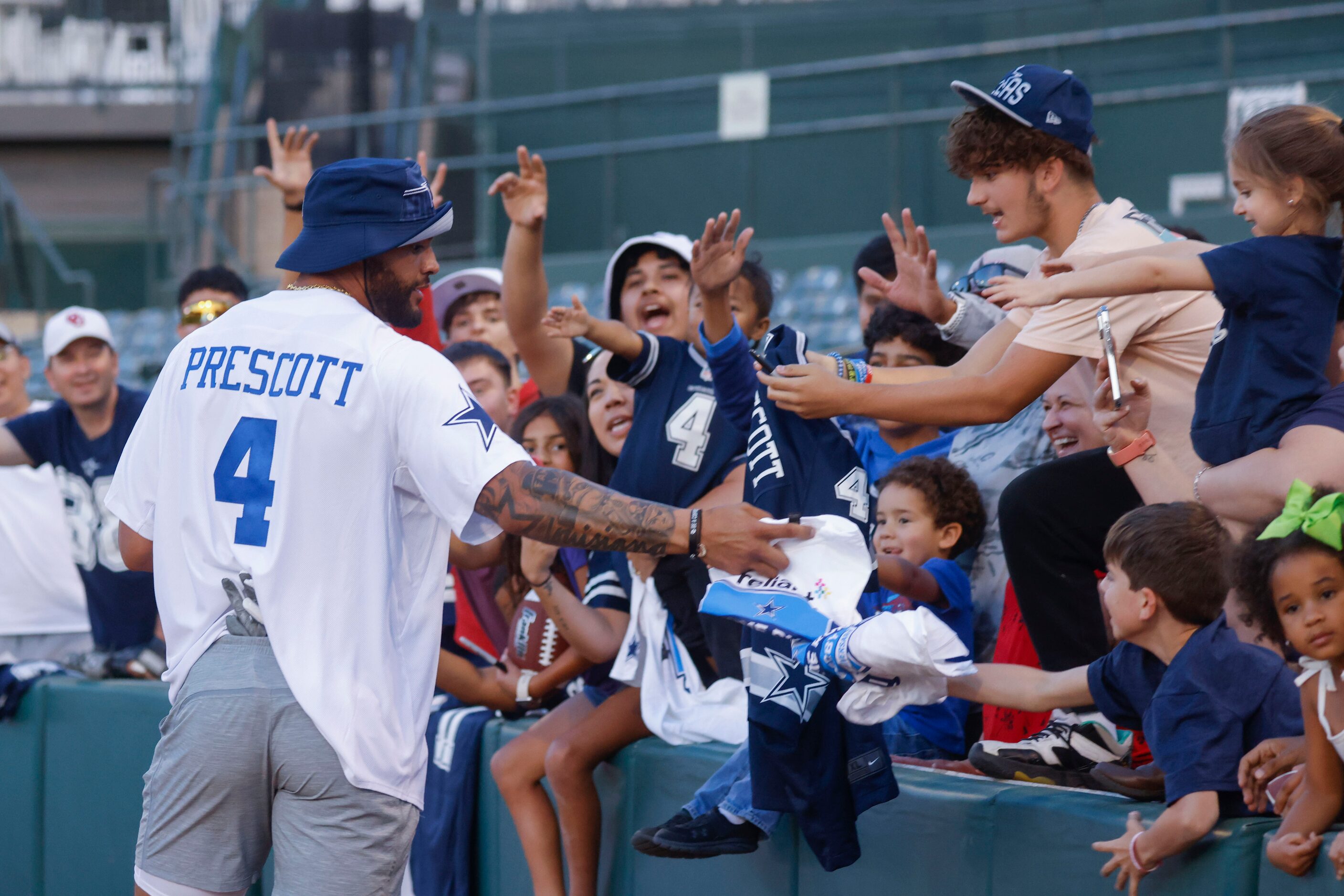 Dallas Cowboys QB Dak Prescott gives t-shirts to fans during the annual home run derby on...