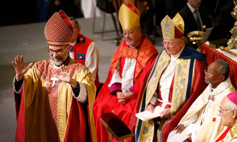 Bishop George R. Sumner acknowledges an applause during a service for the ordination and...