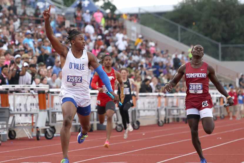 Duncanville anchor Dakorien Moore, left, gestures after crossing the finish line first in...