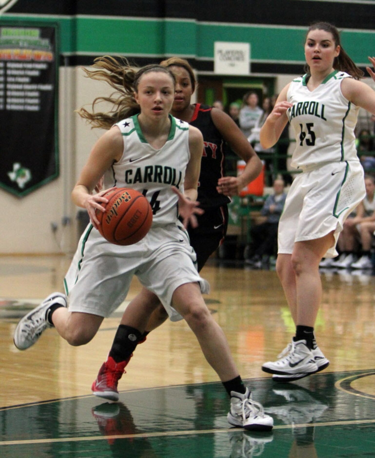 Southlake Carroll guard Kennedy Leonard (14) drives the lane past the defense of Euless...