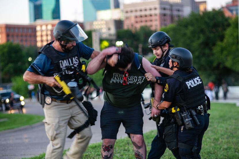 Sgt. Roger Rudloff (left) helps tackle protester Parker Nevills, who ran toward the officers...