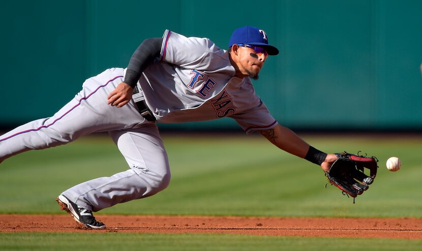 Texas Rangers second baseman Rougned Odor can't reach a ball hit for an RBI single by Los...